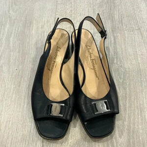 Salvatore Ferragamo black leather slingback sandals with buckle detail.